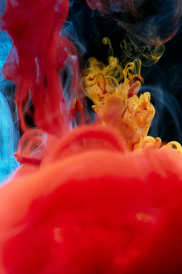 Colorful abstract ink drops creating a dynamic visual effect in water.